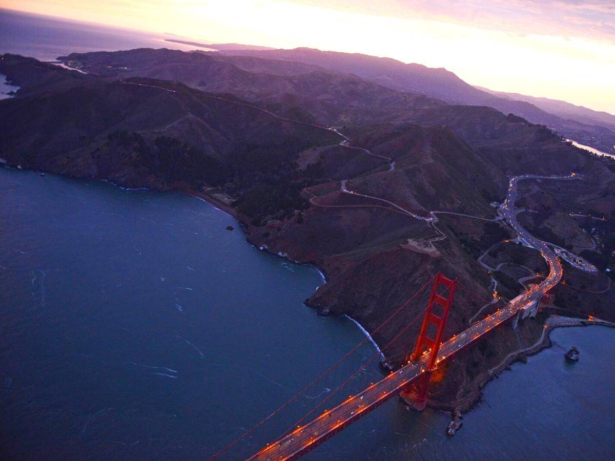 an aerial view of golden gate bridge in san francisco during sunset taken from a helicopter - California Places, Travel, and News.