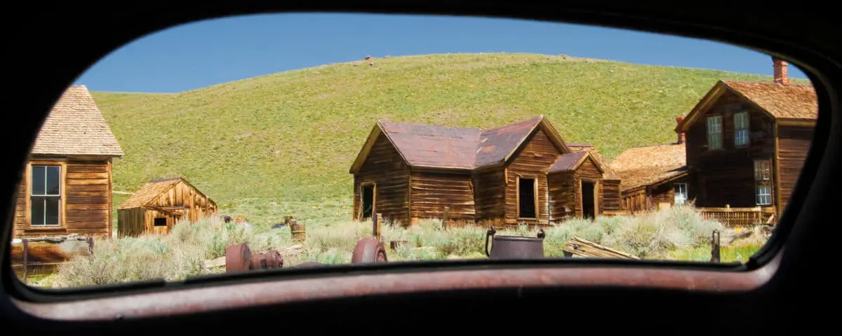 Abandoned buildings viewed through from a mirror of a car Bodie Ghost Town Bodie State Historic Park Mono County California USA - California Places, Travel, and News.