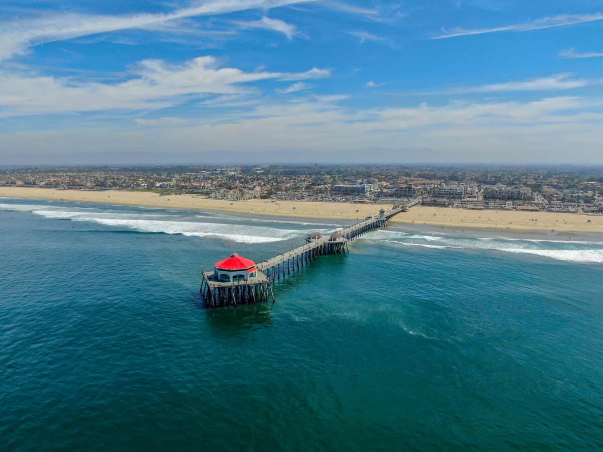 Aerial view of Huntington Pier beach and coastline during sunny summer day Southeast of Los Angeles. California. destination for surfer and tourist. - California Places, Travel, and News.
