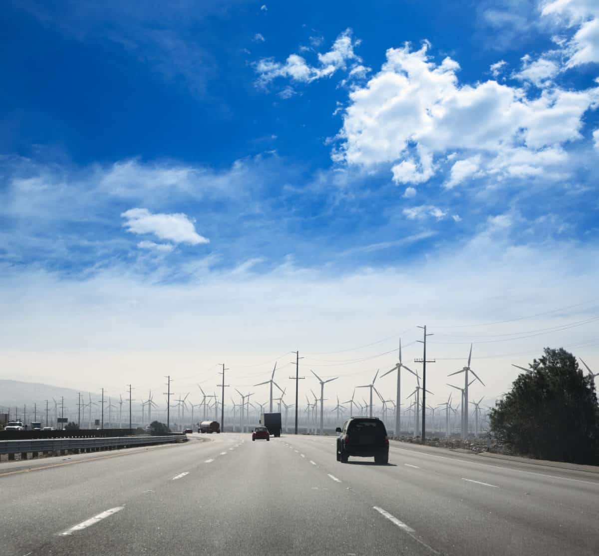 California road with electric windmills aerogenerators and traffic. - California Places, Travel, and News.