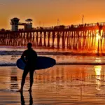 A silhouetted surfer waits for the perfect set - California Places, Travel, and News.