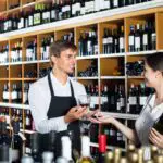 Wine seller and customer in wine shop - California Places, Travel, and News.