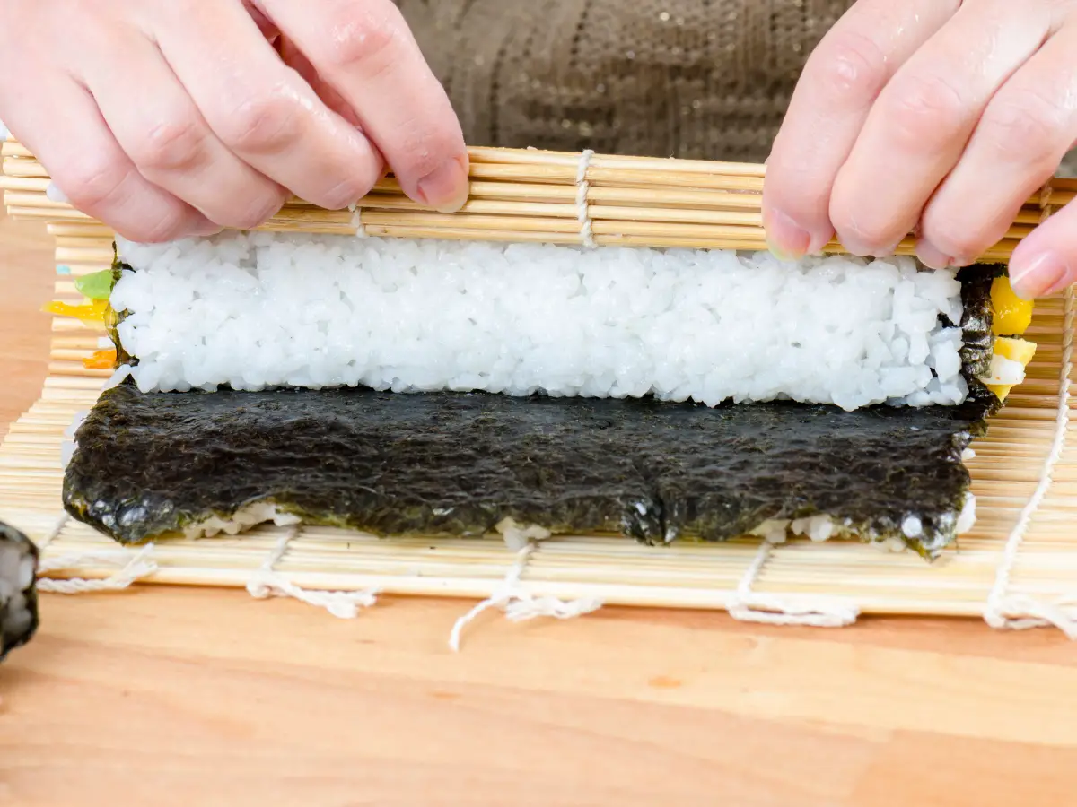 Woman making california roll 2 - California Places, Travel, and News.