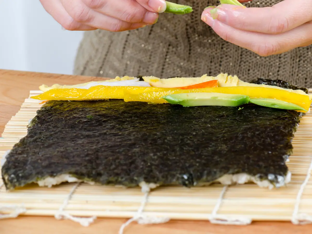 Woman making california roll 3 - California Places, Travel, and News.